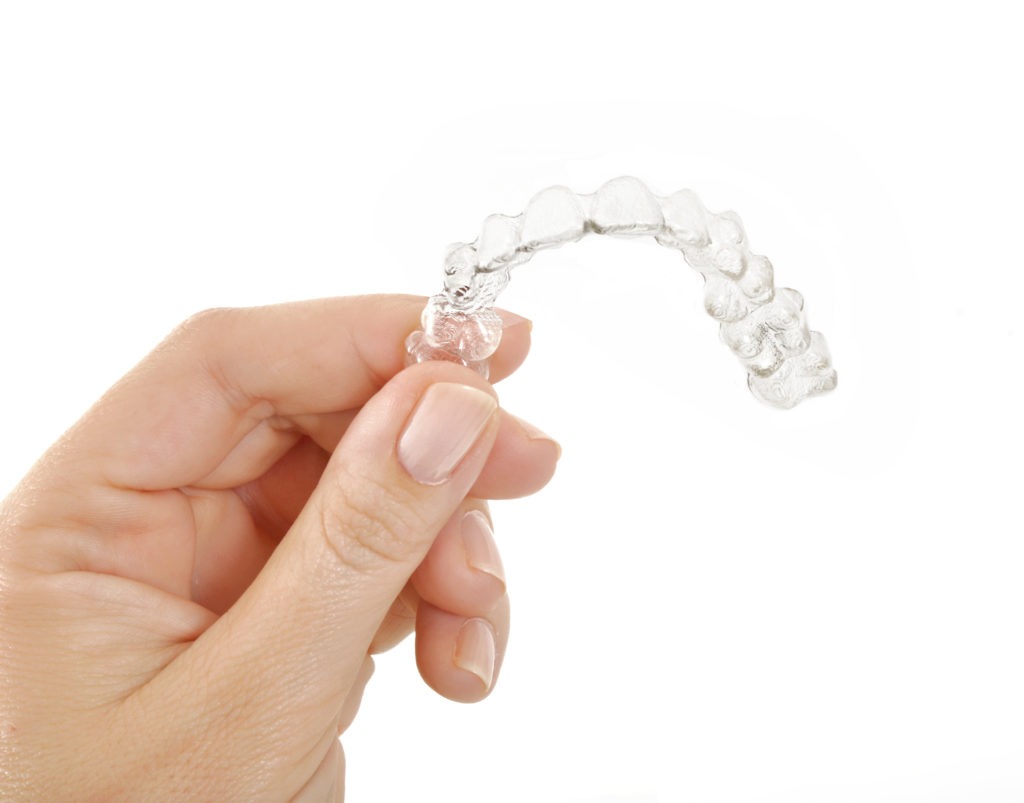 hand holding Invisalign retainer 